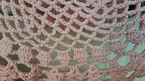Light pink crocheted yarn pattern with intricate handmade interlocking loop Stock-Fotos