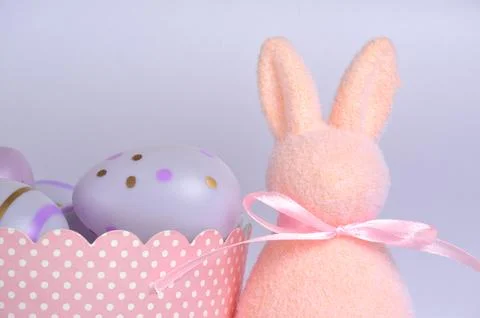 Light pink Easter bunny and purple eggs. Purple background. Easter. Stock Photos