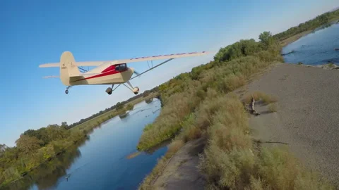 Light plane flying down a river Stock Footage 240120913