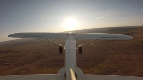 Light plane flying over a river and dam in savannah Video stock 310985021