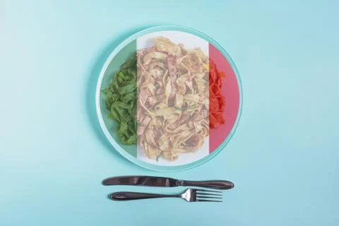 A light plate with pasta, inside of which the flag of Italy. Stock Photos
