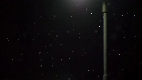 Light pole illuminates snow falling snow. Black background. 库存影片 149780243