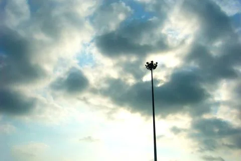 Light poles in front of a dramatic evening sky Stock Photos