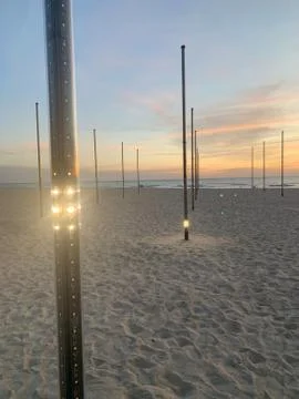 Light posts on tropical beach at sunset Stock Photos