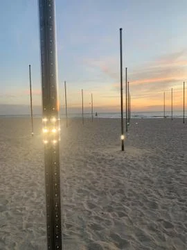 Light posts on tropical beach at sunset Stock Photos