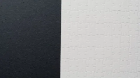 Light puzzle segments assembled on dark surface showing missing pieces closeup Stock Footage 332308010