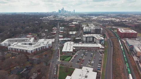 Light rail passes traditional freight train in NODA neighborhood of Charlot.. Stock Footage 331398048