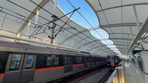 Light rail train leaving station platform under modern canopy structure Stock Footage 331916114