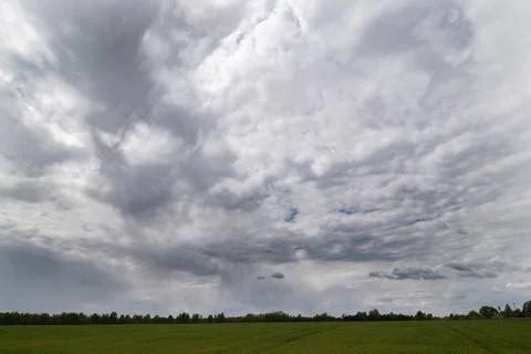 Light rain clouds over the fields, with a shadowy stretch Stock Photos