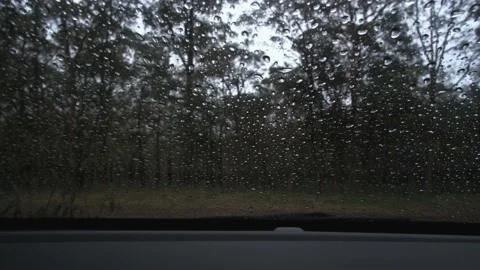 Light rain falling on car windshield viewed from inside the car Stock Footage 206529244