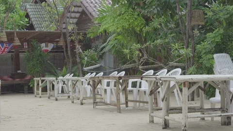 Light rain falls on a lonely tables and chairs in outdoor cafe Stock Footage 87054067