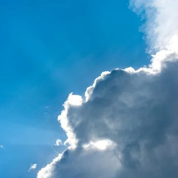Light ray from sun behind cloud in the blue sky Stock Photos