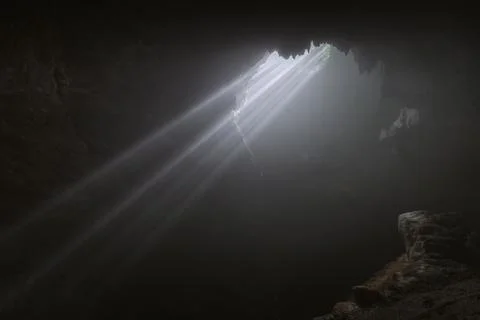 Light rays hitting limestone inside dark deep cave called Jomblang cave whi.. Stock Photos