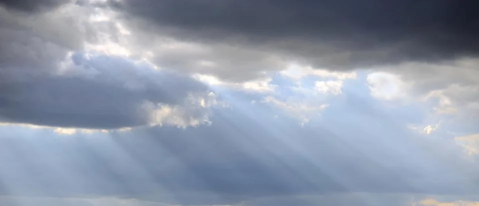 Light rays shine through the dark clouds 写真素材