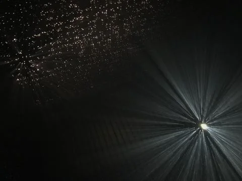 Light rays through small holes in a dark space Stock Photos