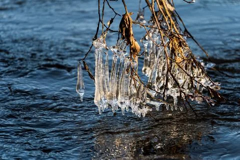 Light reflected through icicles at a river in winter time Stock Photos