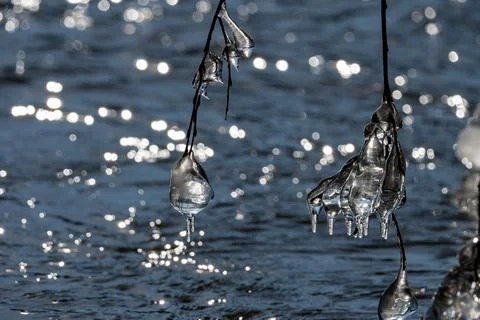 Light reflected through icicles at a river in winter time Stock Photos