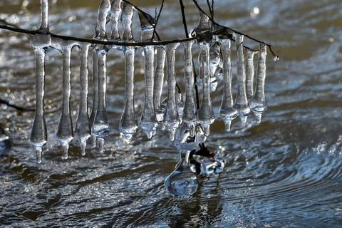Light reflected through icicles at a river in winter time Stock Photos