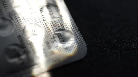 Light reflecting on blister pack of pills Stock Footage 313246804