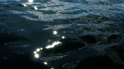 Light reflections on the surface of the rippling dark water Stock Footage 120436281