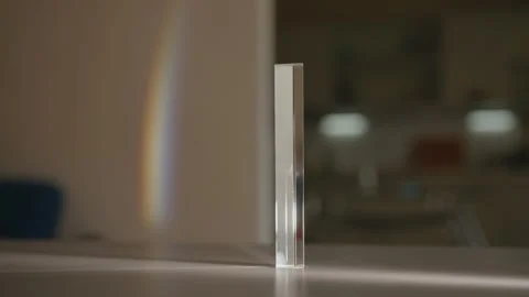 Light refracting through triangular glass prism, creating beautiful rainbow Stock Footage 311569088