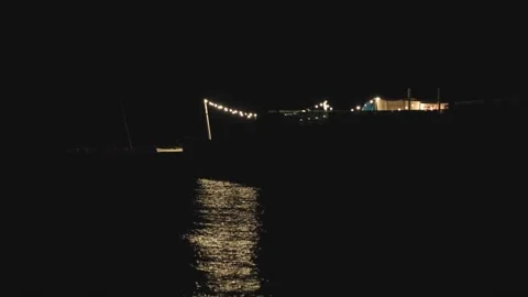 Light of retro garland make reflection at water on the beach at night Stock Footage 160890429