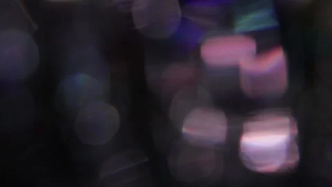 The light rises and falls, creating a brilliant colored bokeh on a black backgro Видео 317478540