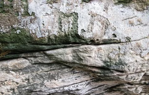 Light rock covered with moss. The texture of a hilly cave. Stock Photos