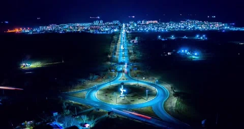 The light on the roundabout at night and movement of cars to the bright town. Stock Footage 151307106