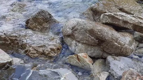 Light sea surf close-up. Small waves wash over the stones. Vidéo 157055624