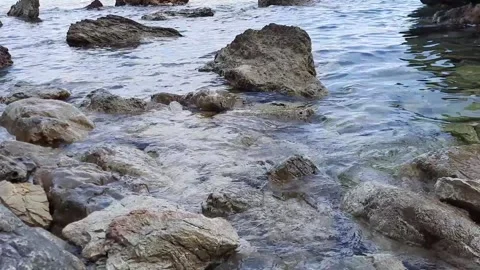 Light sea surf close-up. Small waves wash over the stones. Stock Footage 157057139
