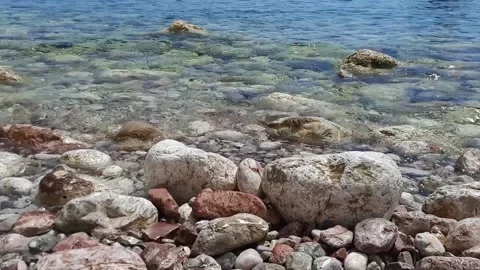 Light sea surf close-up. Small waves wash over the stones. Stock Footage 157058316