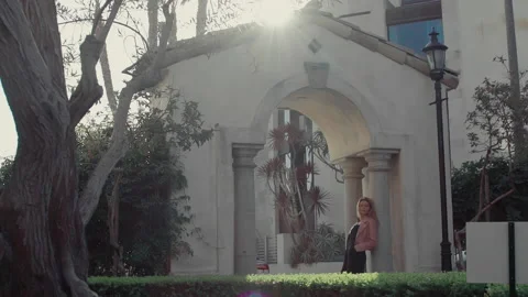 Light of the setting sun in the park and a young woman stands in the arch Stock Footage 151224299