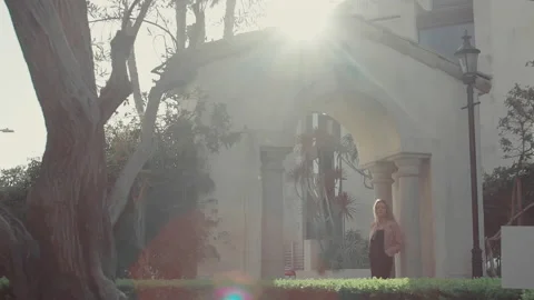 Light of the setting sun in the park and a strolling woman 4K Stock Footage 151224575