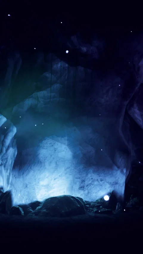 Light shines in dark cave with blue glow and rocks in the background Stock Footage 334106585