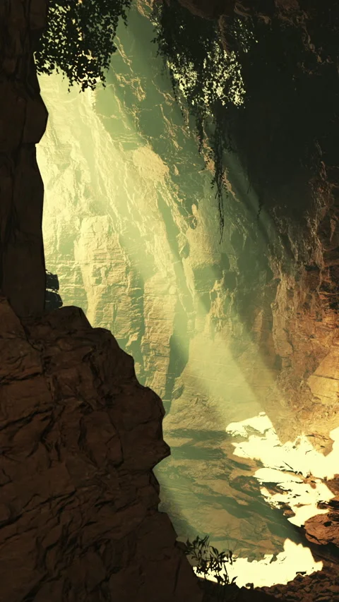 Light shines down into a cave with rocky walls and a river flowing below Stock Footage 339508748
