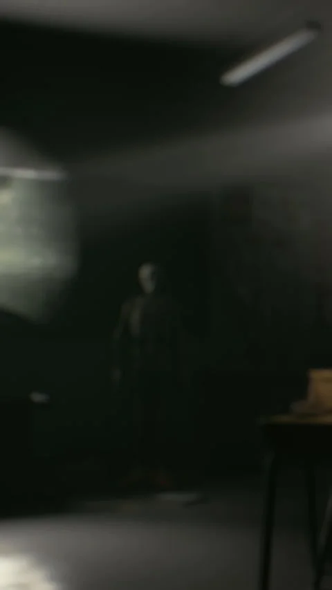 Light shines on a person standing in a dark room with a table Stock Footage 339396595