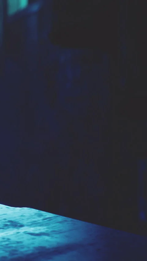 Light shines on a table and reveals textures in a dark room at night Vídeo Stock 341981837