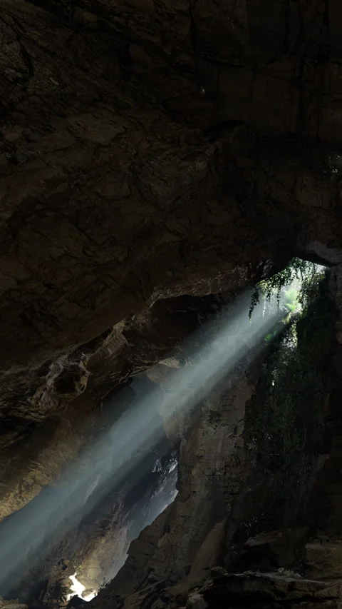 Light shines through a cave opening creating a natural landscape view Stock Footage 334172989