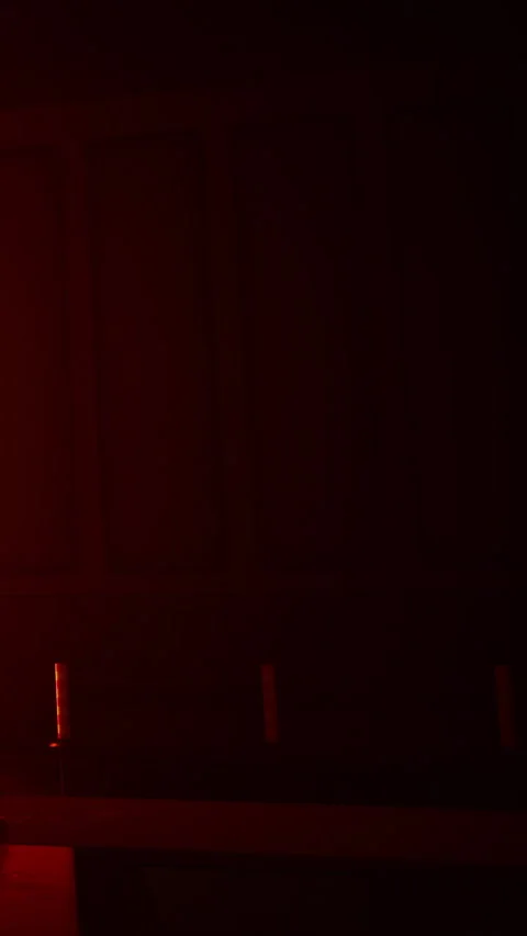 Light shines through a dark room with red color in the background Stock Footage 335354621
