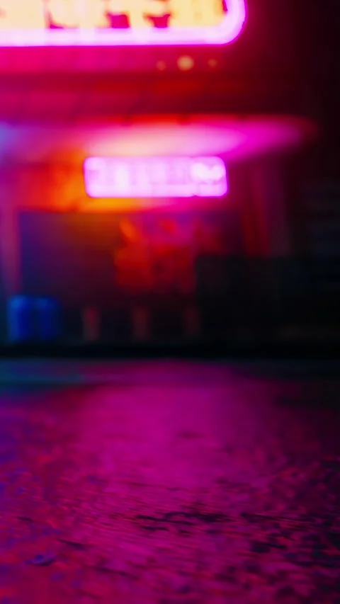 Light shines on wet pavement outside a bright neon sign at night Stock Footage 342343726