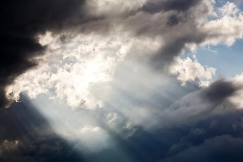 Light shining throug dark clouds Stock Photos