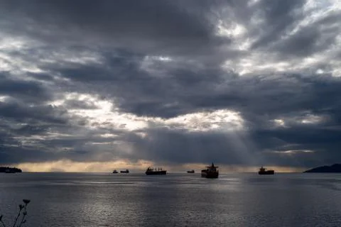 Light shining through some breaks from an otherwise dark and cloudy sky. Stock Photos