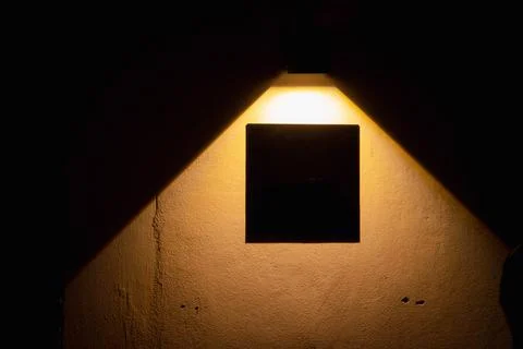 A light is shining on a wall, creating a shadow Stock Photos