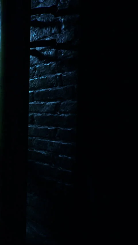 Light shining on a wall in a dark space with a green pillar Stock Footage 340258898
