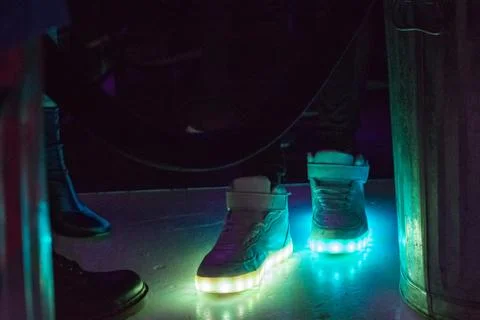 Light up shoes reflecting on floor in nightclub Stock Photos
