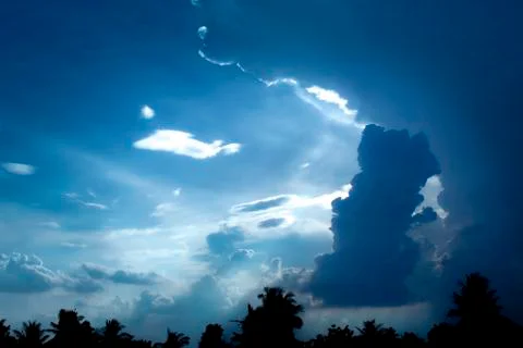 The light shone through the gray clouds before the rain. Stock Photos