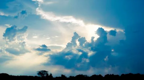 The light shone through the gray clouds before the rain. Stock Photos