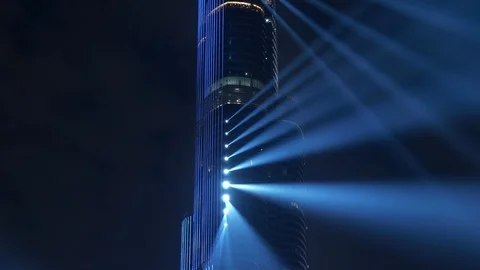 Light Show Beaming Lights on High Rise Skyscraper Building at Night Stock Footage 103597712