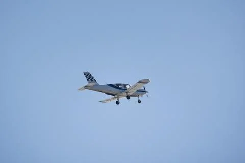 Light single-engine aircraft flies in blue sky Stock Photos